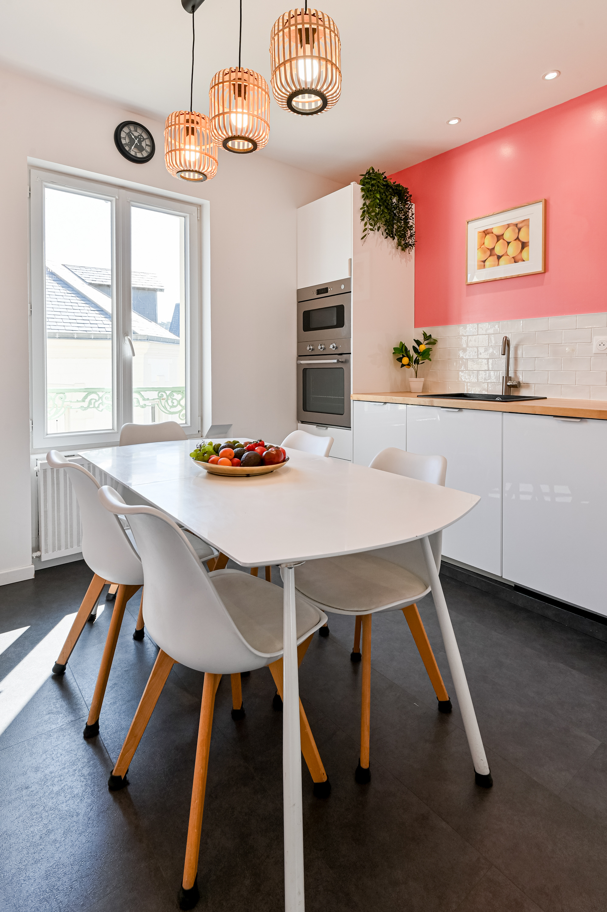 La cuisine avec table à manger et mur corail
